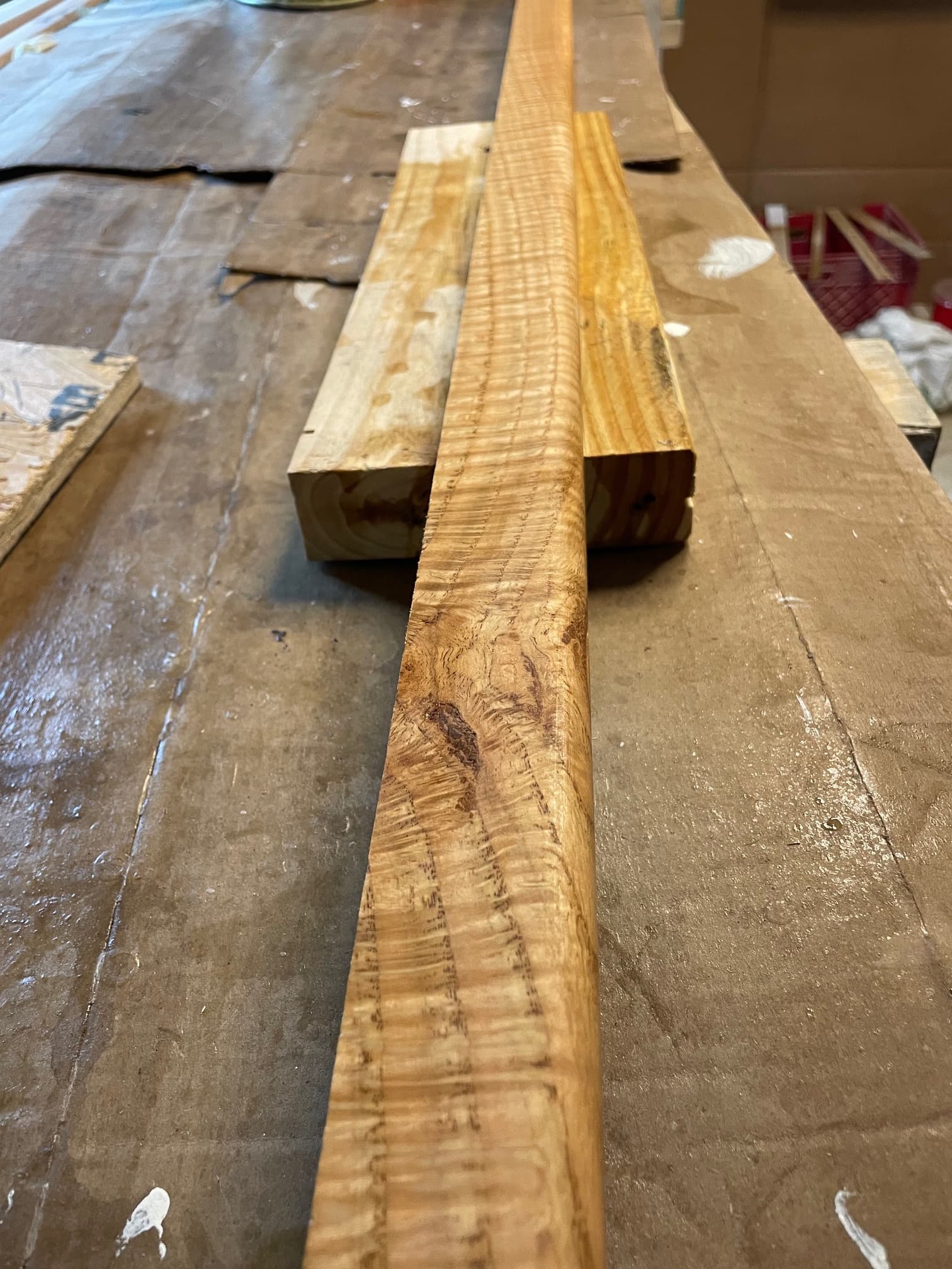 Long piece of wood with a prominent curly grain pattern resting on a workbench.